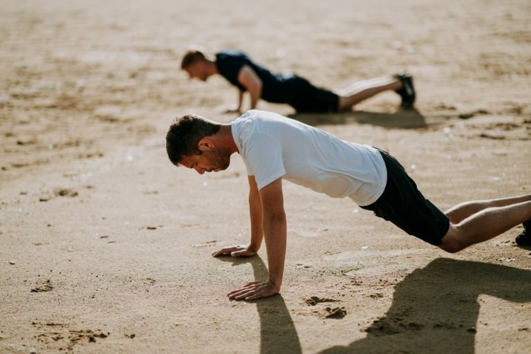 a man doing a handstand on the beach