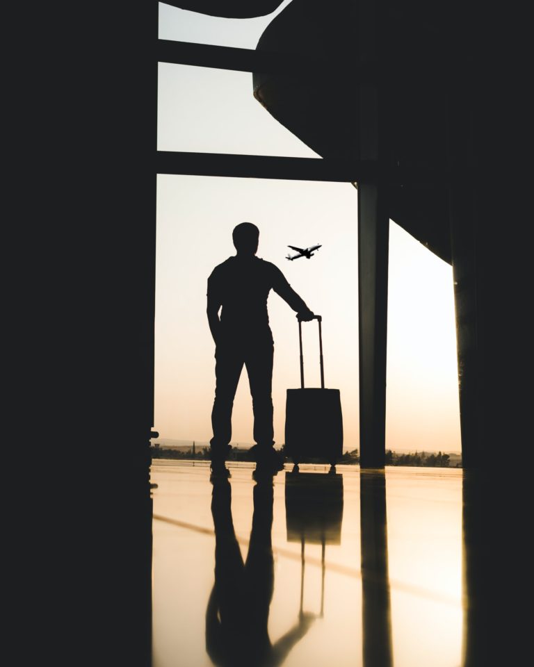 a person standing in a doorway with a suitcase