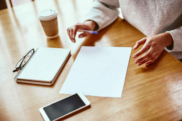 a person writing on a piece of paper