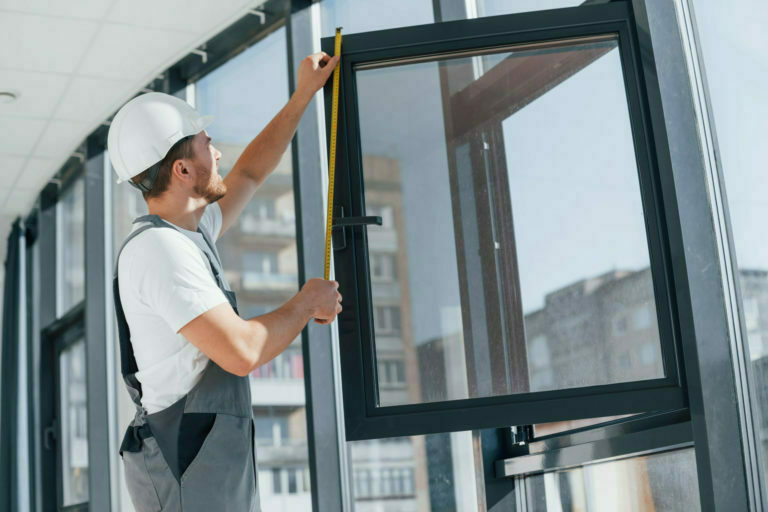 Holding window. Repairman is working indoors in the modern room
